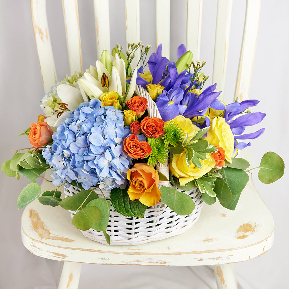 Mixed Flower Arrangement with Irises, Roses, Lilies in Wicker Basket – how the gift is presented
